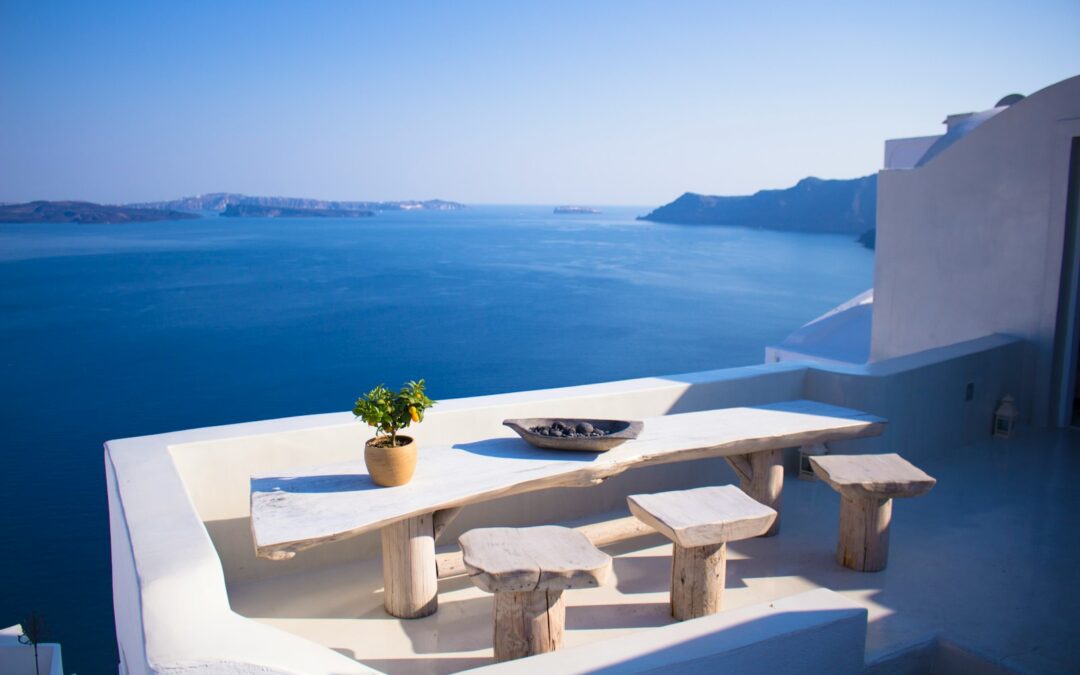 bench and dining table near body of water under calm sky